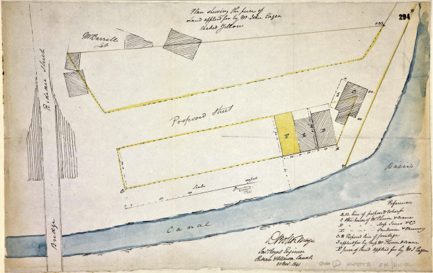 Eine detaillierte Karte auf Papier mit beschrifteten Straßen, Gebäuden und Sehenswürdigkeiten, begleitet von erklärendem Text über die Größe, Lage und Merkmale der Stätte.