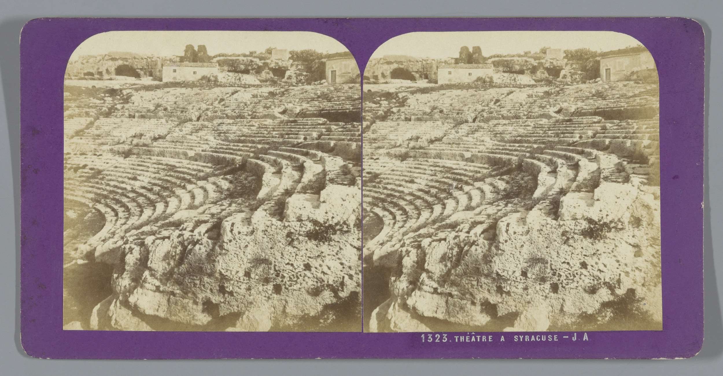 Schwarze und weiße stereoskopische Ansichten eines antiken Amphitheaters in Syrakus, das Sitzreihen, Strukturen, Vegetation und Himmel zeigt.