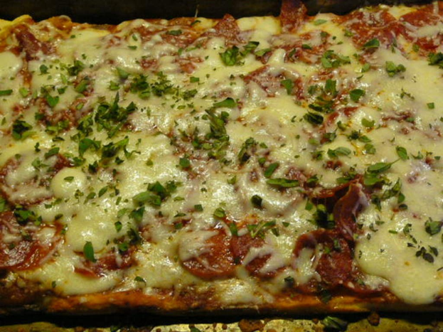 Ein Stück Pizza mit Käse auf einem Tablett.