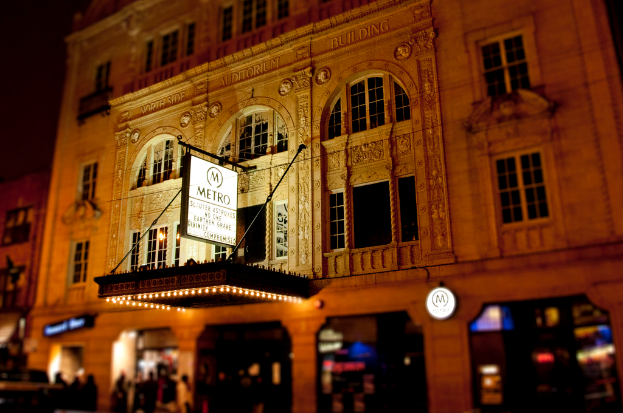 Ein gelbes Gebäude mit einem weißen Schild, auf dem "Metro" über Läden an der Vorderseite steht.