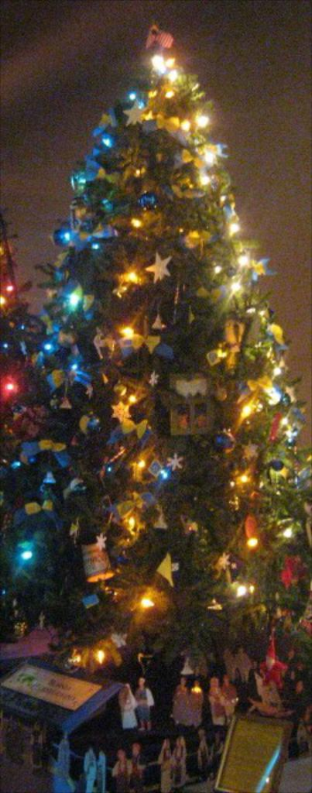 Ein geschmückter Weihnachtsbaum mit Figuren darauf auf einem Tisch darunter.