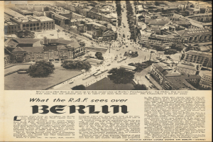 Schwarz-weiß-Foto eines alten Zeitungsartikels mit einer Stadtansicht, die Gebäude, Bäume und Fahrzeuge zeigt, zusammen mit Text.