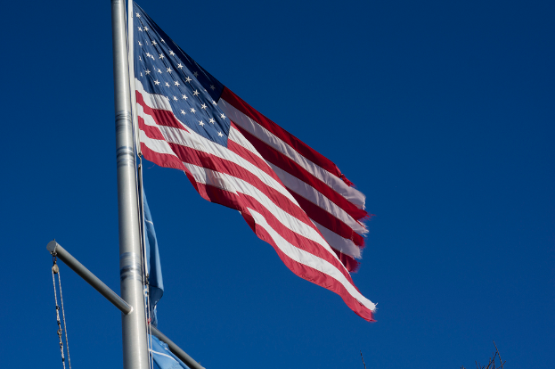 Eine US-Flagge ist auf der linken Seite des Bildes zu sehen.