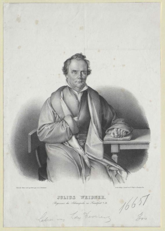 Portrait von Julius Weidner, einem deutschen Philosophen, der an einem Tisch sitzt und einen Anzug und eine Krawatte trägt, mit einem ernsten Gesichtsausdruck, die Hände auf dem Tisch ruhend, direkt in die Kamera schaut.