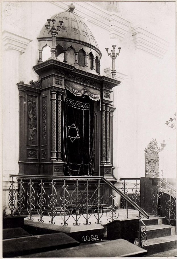 Schwarzes und weißes Foto einer jüdischen Synagoge in New York City, das Treppen, Geländer, Säulen, eine Tür und eine Wand zeigt.