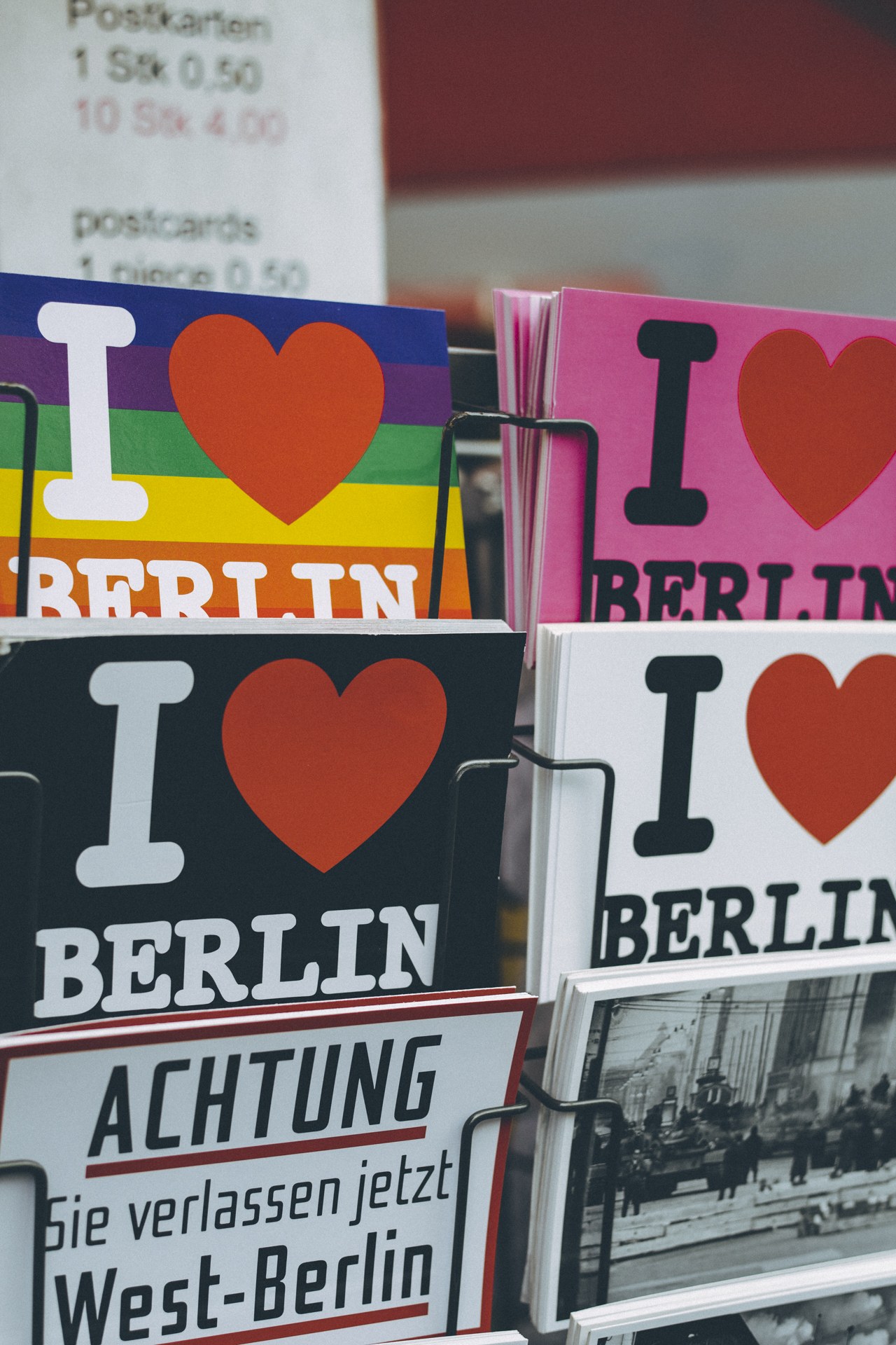 Ein Displayständer mit Büchern und Postern, auf denen der Satz 'Ich liebe Berlin' steht, vor einem sanft unscharfen Hintergrund.