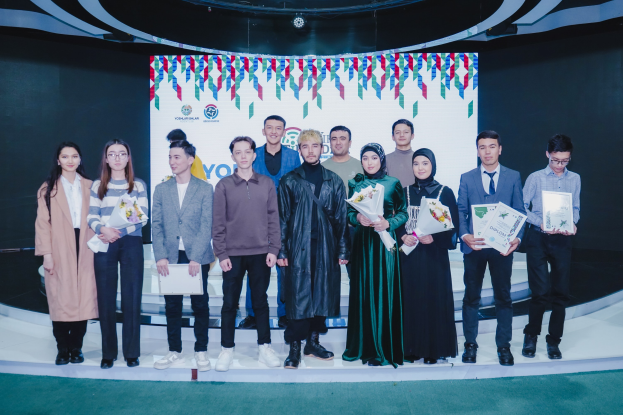 Gruppe von Menschen auf einer Bühne mit Blumensträußen und Urkunden, im Hintergrund ein "Youth Solar Awards 2019"-Plakat