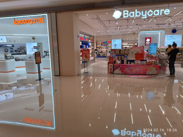 Ein Babyladen in einem Einkaufszentrum mit Menschen, Spielzeugen, Regalen, Schildern, einem Anzeigebildschirm, Deckenleuchten und einem Dach, das sich im Mall of Asia befindet.