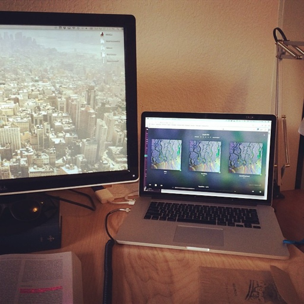 Zwei Computersysteme mit einem Buch vorne und einem Kabel in der Mitte.