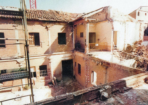 Ein teilweise abgerissener Bau mit einer Absperrung, sichtbaren Fenstern und etwas, das wie eine Leiter aussieht.