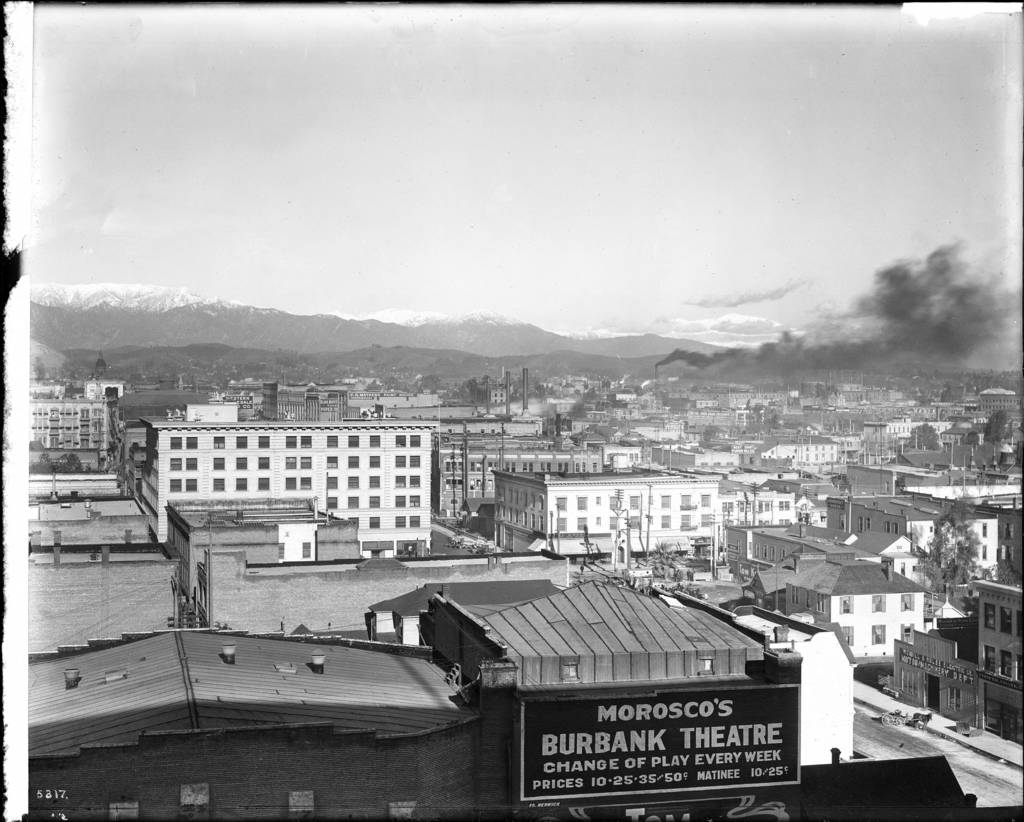 Ein Schwarz-Weiß-Bild von Gebäuden mit einer Fabrik, die Rauch ausstößt.