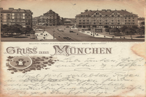 Eine alte Ansichtskarte zeigt eine Münchner Stadtstraße mit Gebäuden, Bäumen, Menschen und Fahrzeugen sowie deutschem Text unten.