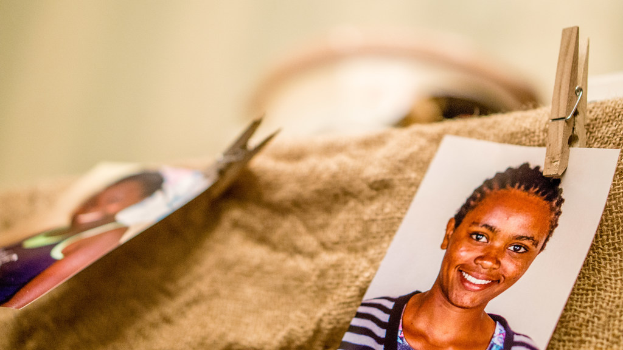 Auf einem Tisch befinden sich eine Klammer, ein Passfoto im Format 4x6 cm und ein Stoffstück auf der rechten Seite, mit einem unscharfen Hintergrund und linker Seite.