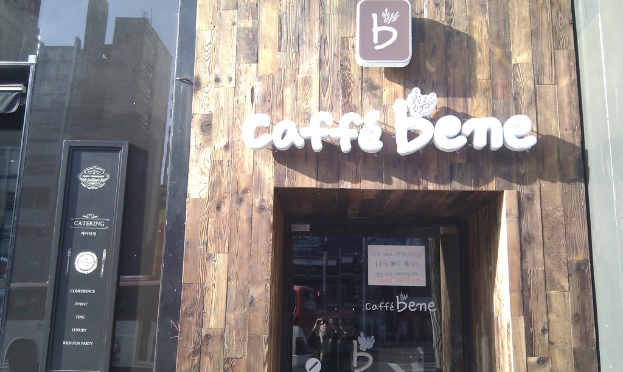 Ein Geschäft mit der Aufschrift 'CAFFE BENES', eine schwarze Tür und eine Glastür.