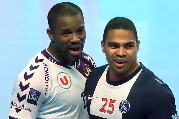 Zwei Männer in weiß-blauen T-Shirts auf einem Fußballfeld mit einem hellblauen Hintergrund, die einen Sieg feiern.