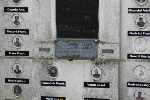 Gedenktafel an einer Wand mit Fotografien und Text, die an die Opfer des Zweiten Weltkriegs erinnert.